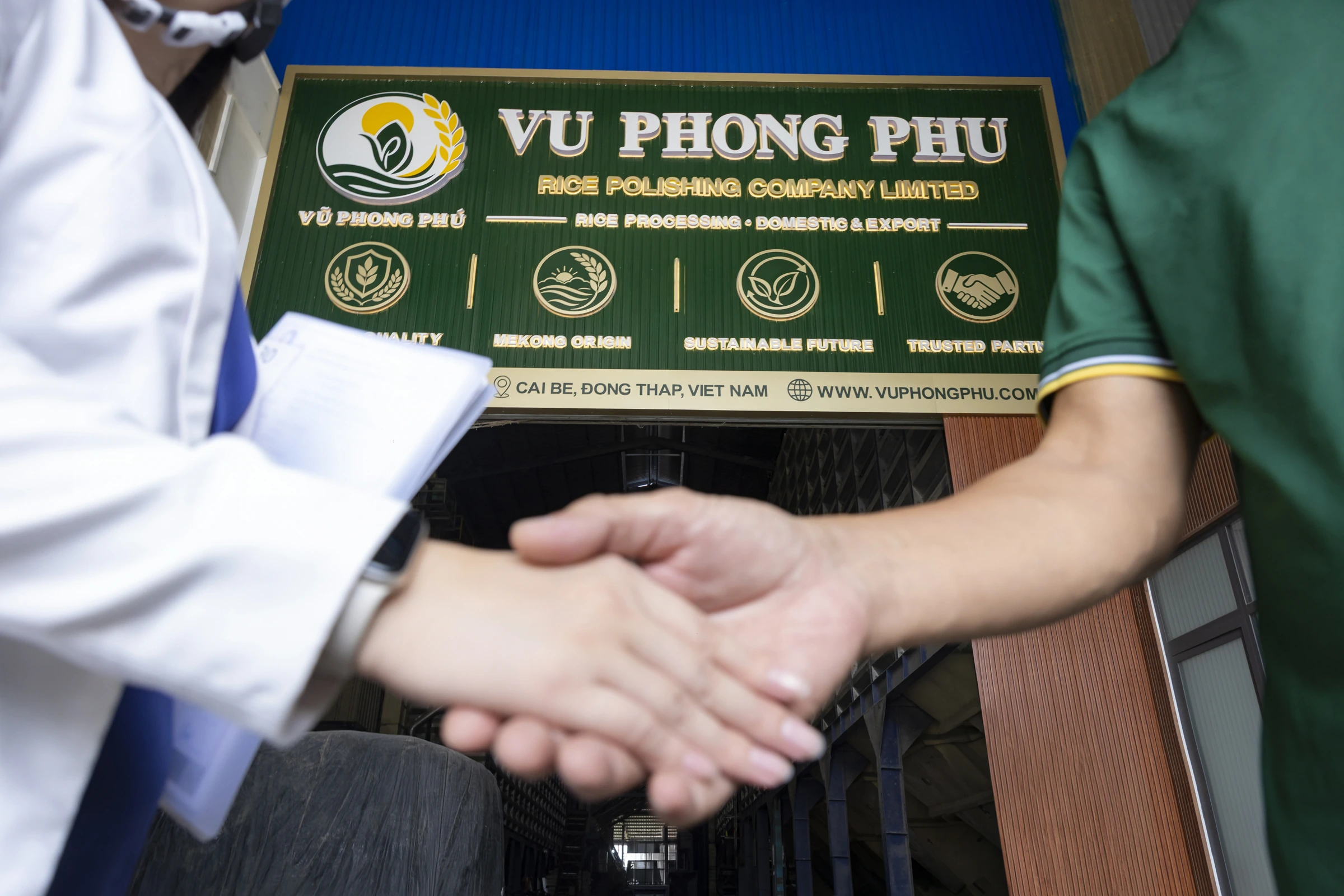 A partnership handshake at the Vũ Phong Phú company entrance