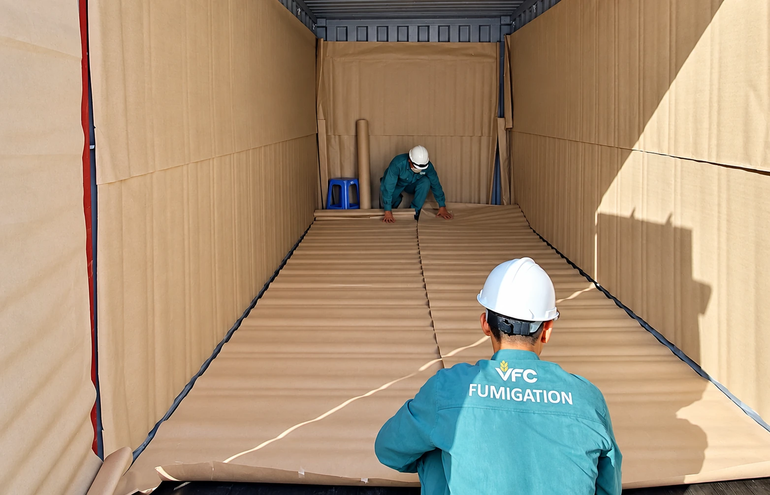 VFC personnel lining a container with paper
